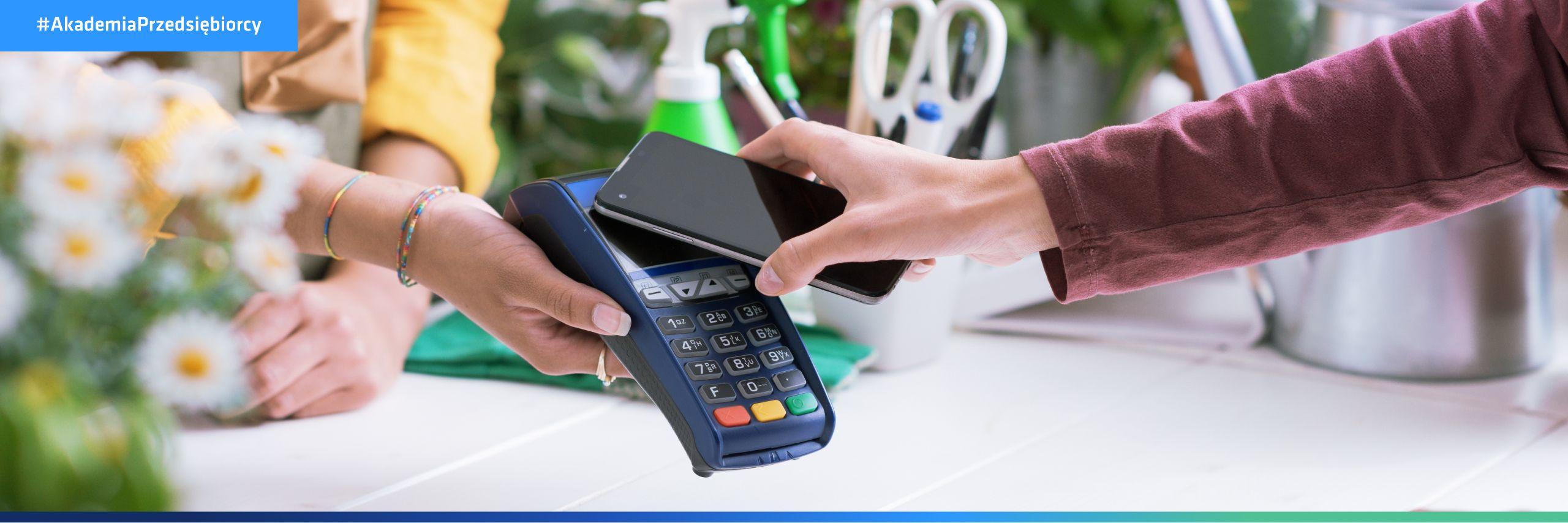 Kobieta płaci zaliczkę w firmie usługowej za pomocą telefonu