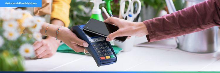 Kobieta płaci zaliczkę w firmie usługowej za pomocą telefonu