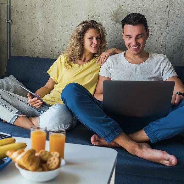 Para gości opłacająca rezerwację online na laptopie